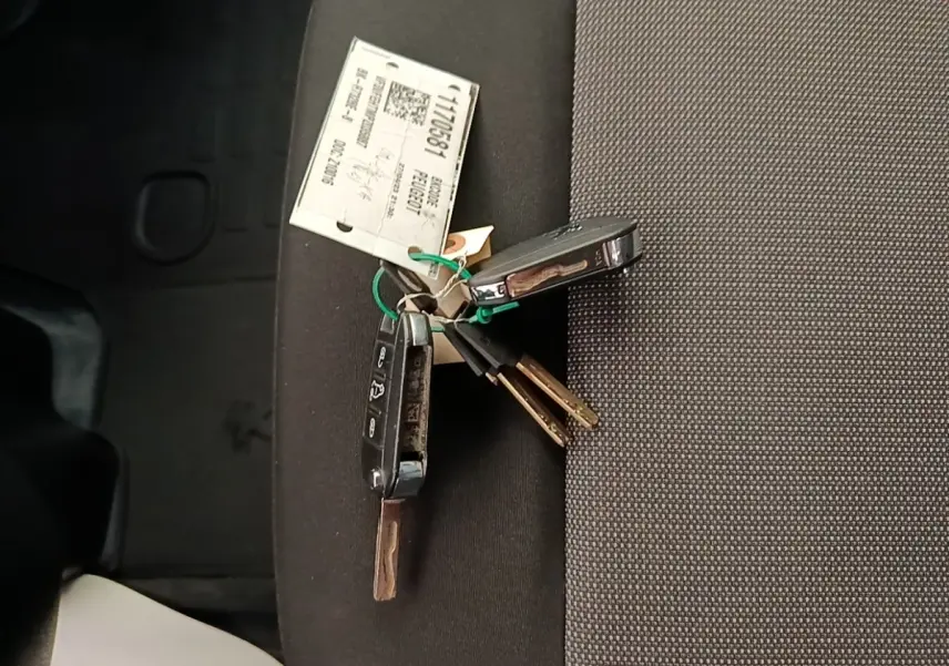Clés de véhicule Peugeot Expert Fourgon posées sur un siège intérieur en tissu gris foncé.