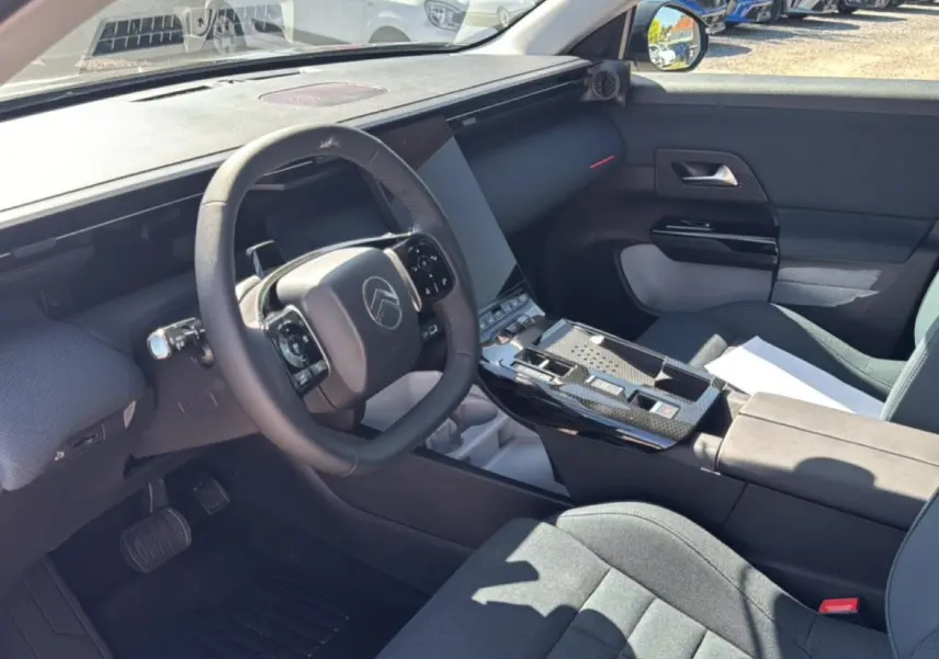 Vue intérieure côté conducteur du Citroën C5 Aircross 2026, volant multifonction et console centrale avec finition noire brillante.