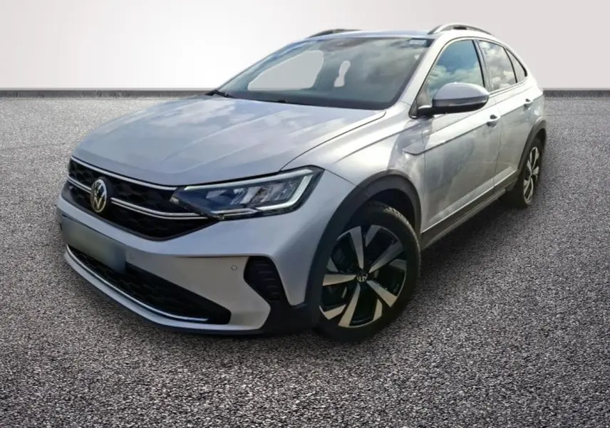 Volkswagen Taigo gris clair vu en 3/4 avant droit, avec jantes noires et phares LED distinctifs.