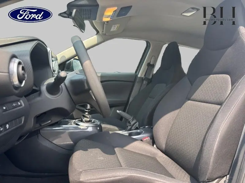 Vue intérieure côté conducteur du Nissan Juke 2023 avec sièges tissu noir et volant multifonction