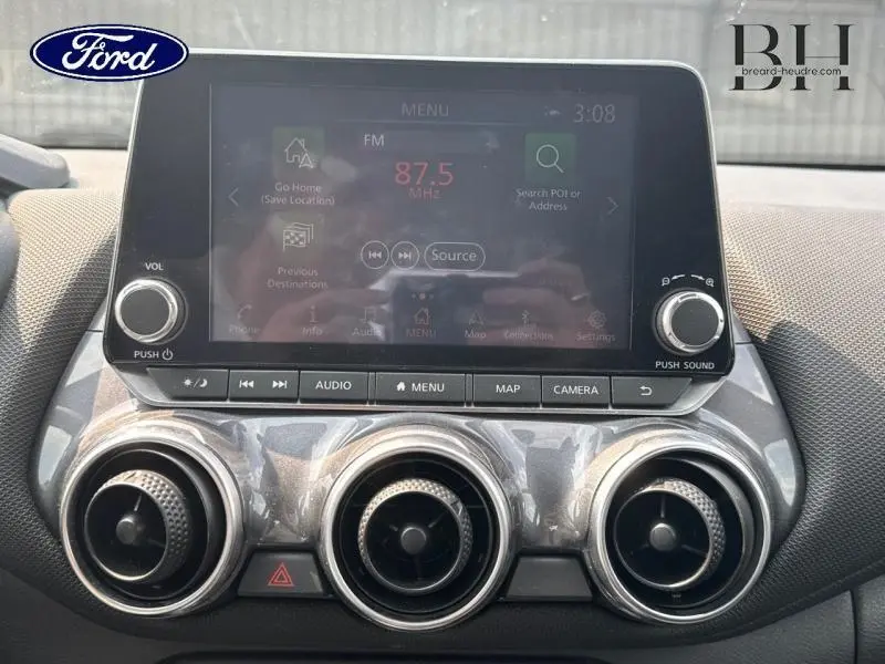 Écran tactile central et commandes audio d'une Nissan Juke gris perle, vue rapprochée de la console avant