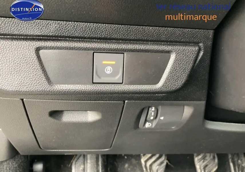 Détail intérieur montrant le bouton de frein de stationnement électrique et les pédales du Dacia Jogger 2025.