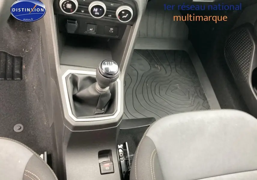 Vue intérieure centrée sur la console centrale et levier de vitesses manuelle du Dacia Jogger vert cèdre 2025.