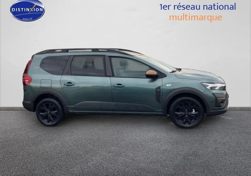Vue de profil côté gauche d'un Dacia Jogger 2025 vert cèdre avec barres de toit et jantes noires.