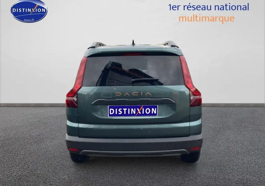 Vue arrière d'un Dacia Jogger 2025 vert cèdre avec feux arrière verticaux et lunette arrière surteintée.