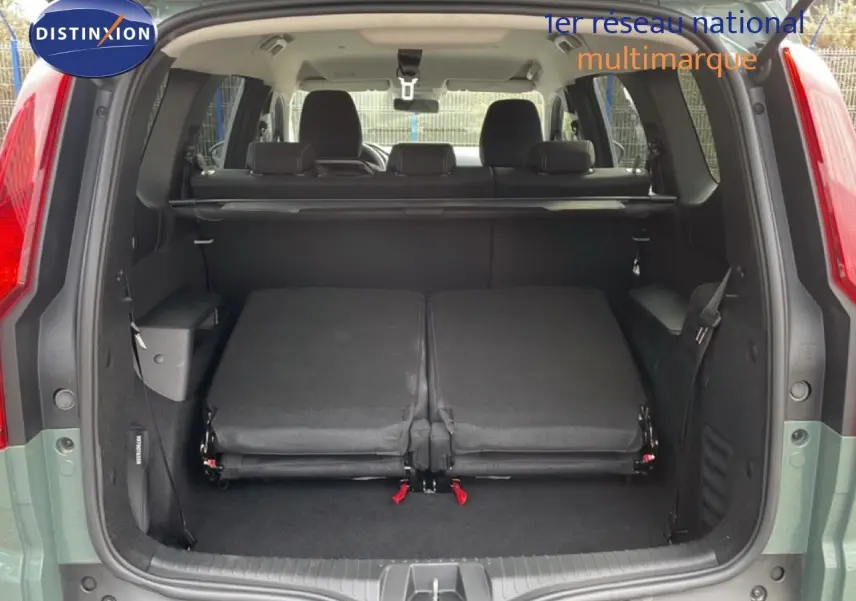 Vue arrière du Dacia Jogger gris schiste métal avec hayon ouvert et sièges arrière rabattus dans le coffre.