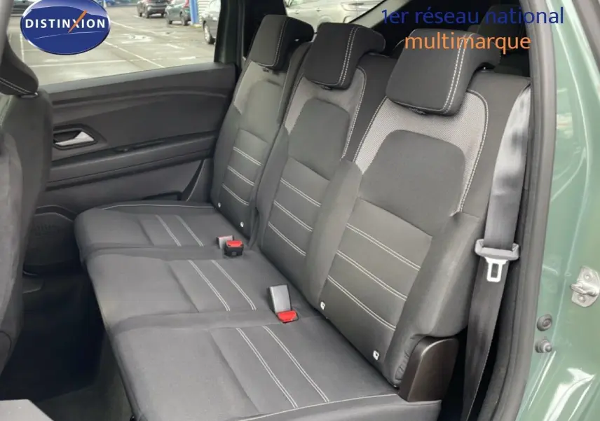 Vue intérieure côté droit sur la banquette arrière en tissu gris du Dacia Jogger 2025, porte ouverte laissant entrevoir la carrosserie gris schiste.