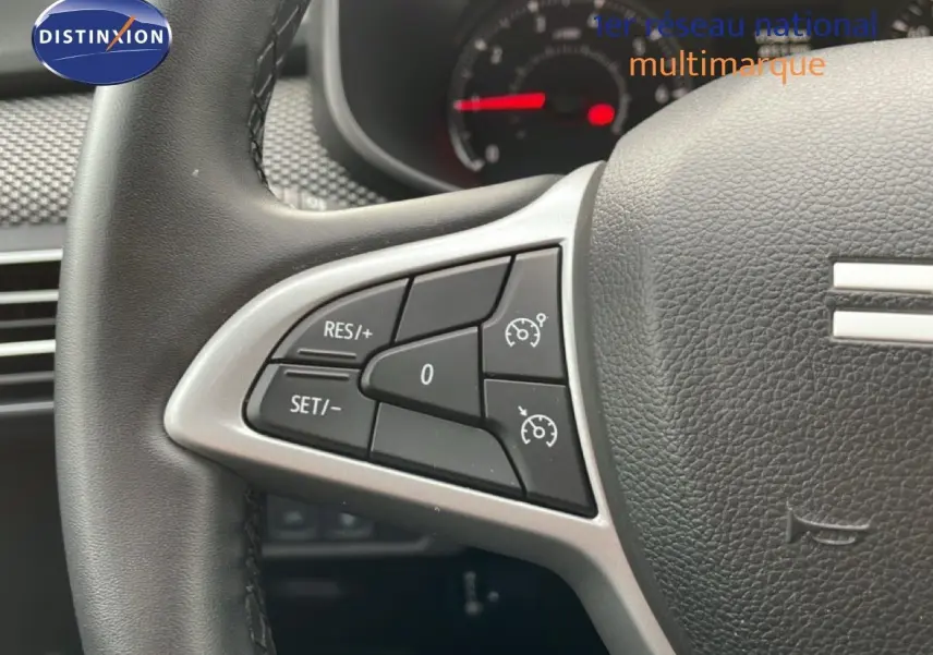 Gros plan sur les commandes au volant côté gauche du Dacia Jogger gris schiste métal, montrant les réglages du régulateur de vitesse.
