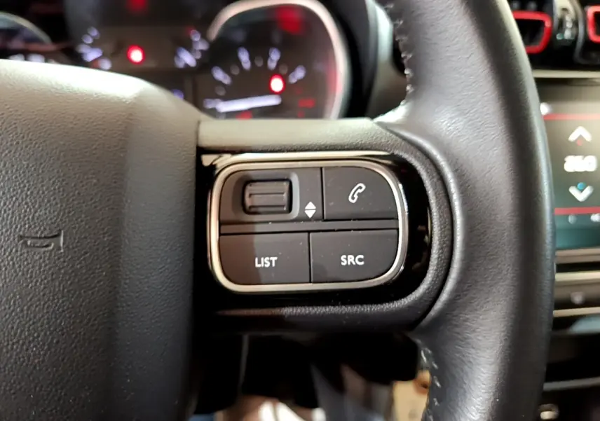 Gros plan sur les commandes gauche du volant cuir du Citroën C3 Aircross 2020, boutons de téléphone et liste visibles.