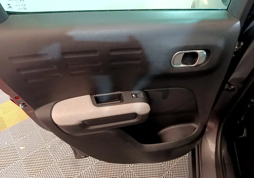 Gros plan sur la porte arrière gauche grise du Citroën C3 Aircross 2020 avec poignée intégrée et accoudoir tissu clair.