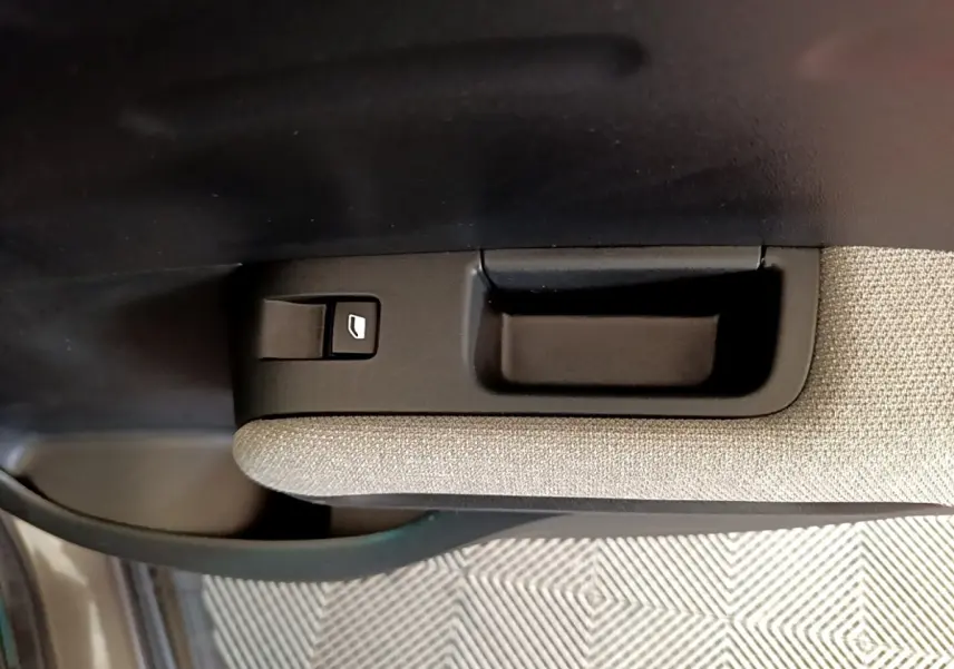 Détail de la commande de lève-vitre sur la porte intérieure côté conducteur d'une Citroën C3 Aircross gris foncé.