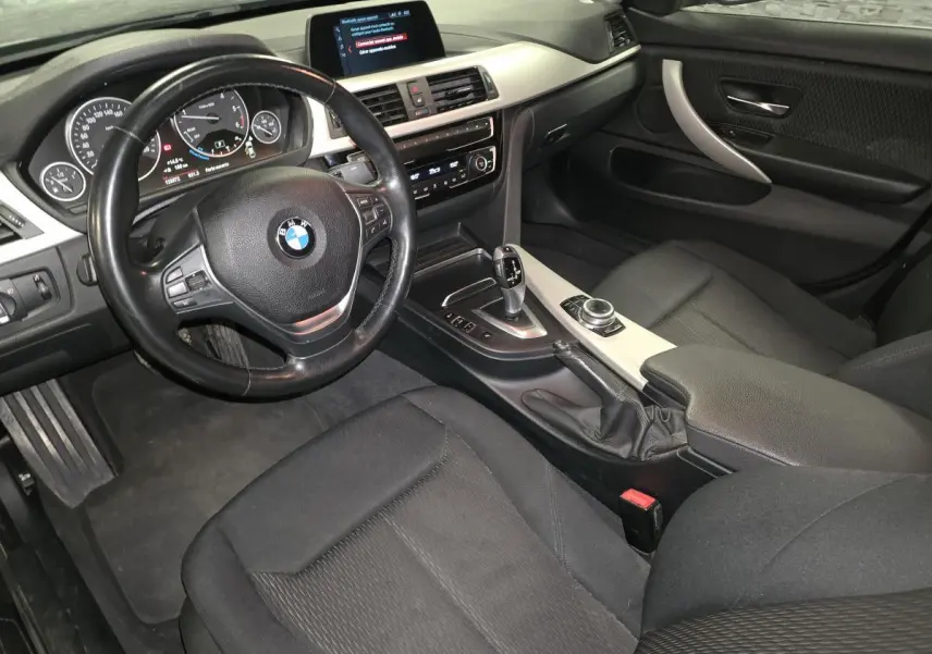 Vue intérieure côté conducteur de la BMW Série 4 420d Gran Coupé 2018 avec sellerie tissu anthracite et console centrale aluminium satiné.