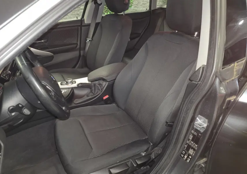 Vue intérieure côté conducteur de la BMW Série 4 Gran Coupé 420d gris foncé, sièges tissu anthracite et console centrale.