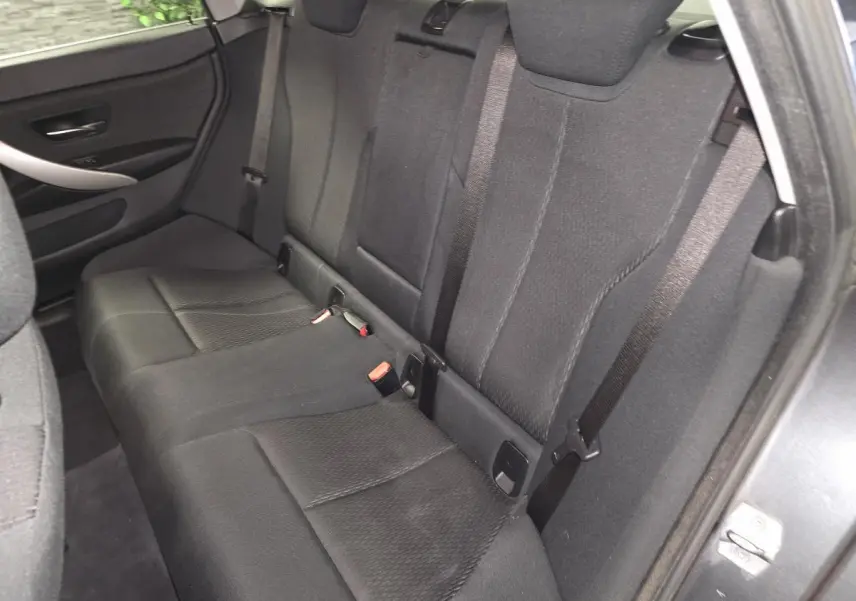 Banquette arrière en tissu anthracite vue côté droit de la BMW Série 4 Gran Coupé gris foncé avec ceintures de sécurité visibles.