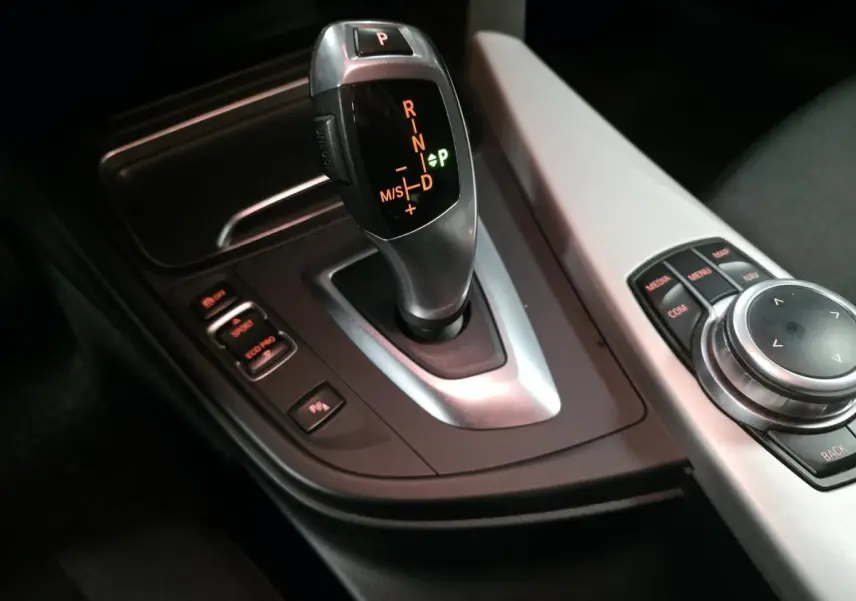 Le levier de vitesse automatique BMW gris satiné avec commandes de mode de conduite et molette iDrive sur console centrale.