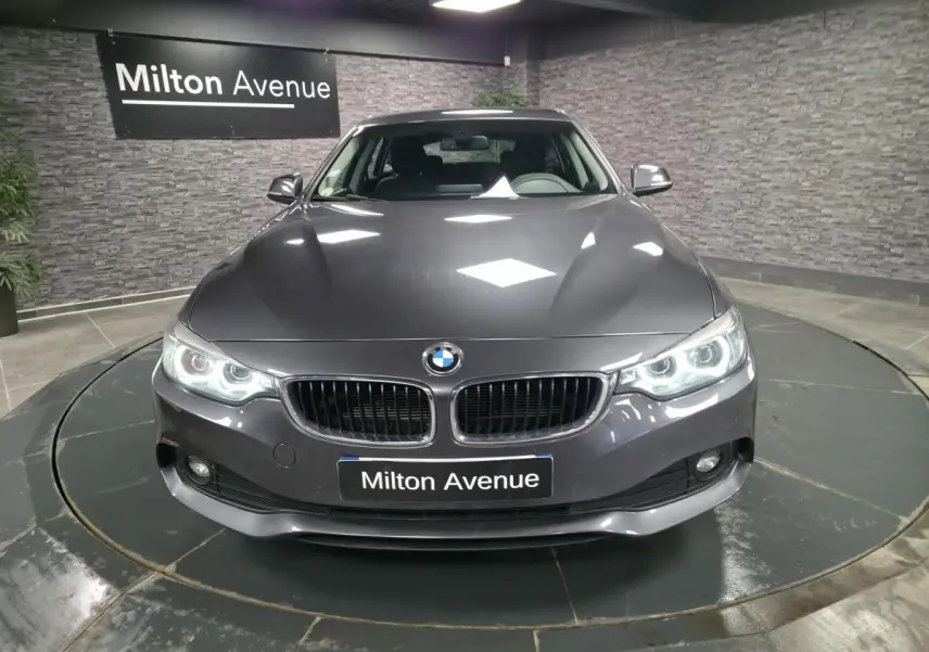 Vue avant d'une BMW Série 4 Gran Coupé gris foncé avec calandre double haricot et phares LED allumés.