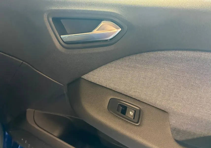 Détail de la porte intérieure côté gauche de la Renault Clio V E-TECH 145 TECHNO 2025 avec tissu gris et poignée argentée.