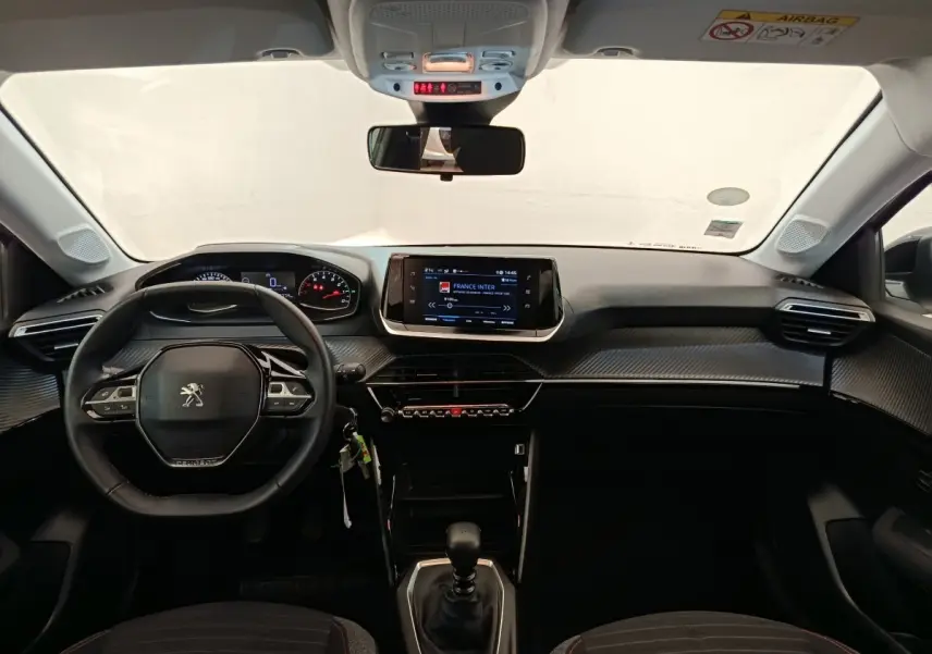 Vue intérieure avant de la Peugeot 208 BlueHDi 100 S&S Active 2022, volant cuir multifonctions et écran tactile central.