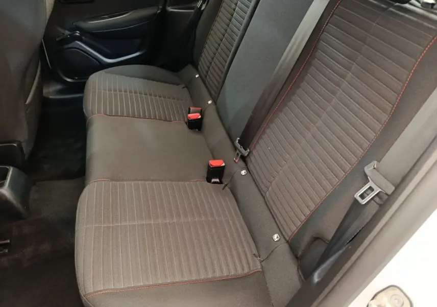 Vue intérieure côté droit sur la banquette arrière noire avec surpiqûres rouges de la Peugeot 208 blanche 2022.