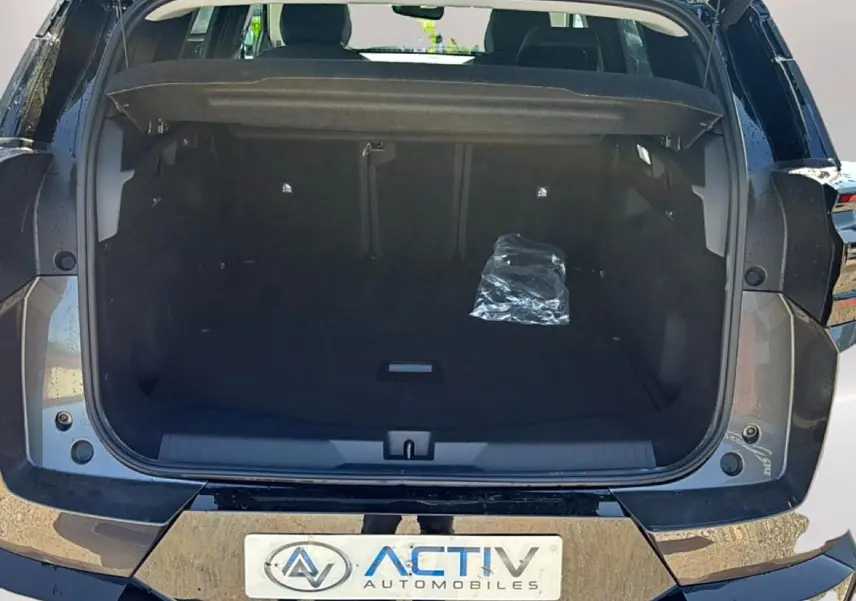 Coffre ouvert vu de l'arrière du Citroën C5 Aircross gris platinium avec hayon électrique et plancher de coffre mobile.