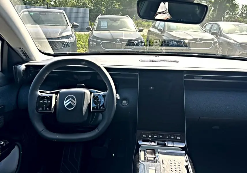 Vue intérieure frontale du tableau de bord du Citroën C5 Aircross gris platinium avec volant multifonction et écran tactile vertical.