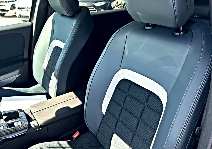 Gros plan sur les sièges avant bi-ton gris et noir du Citroën C5 Aircross avec accoudoir central visible.