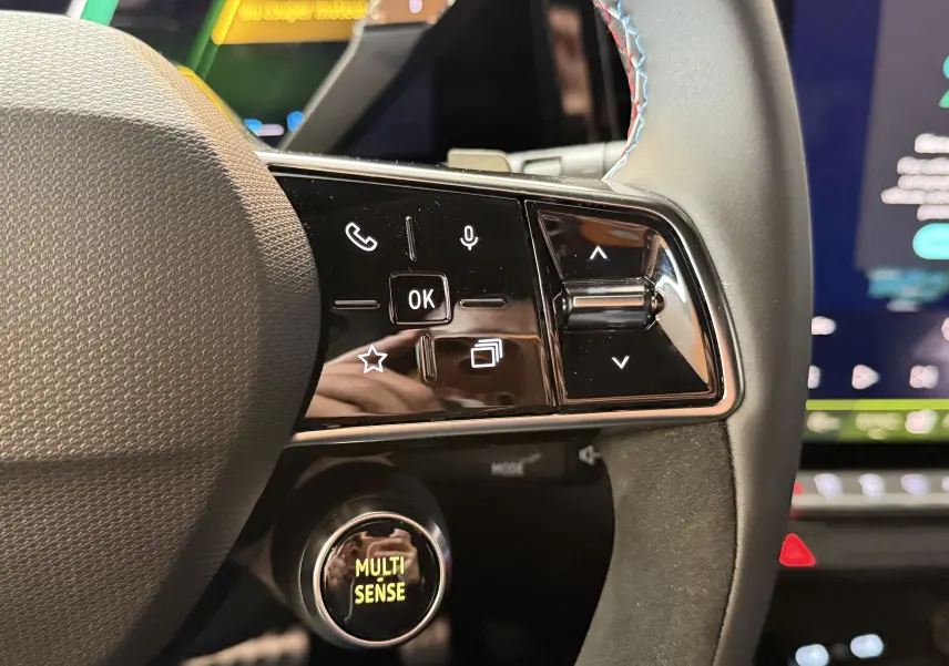 Gros plan sur les commandes à droite du volant du Renault Austral E-Tech 200 Esprit Alpine avec surpiqûres tricolores.