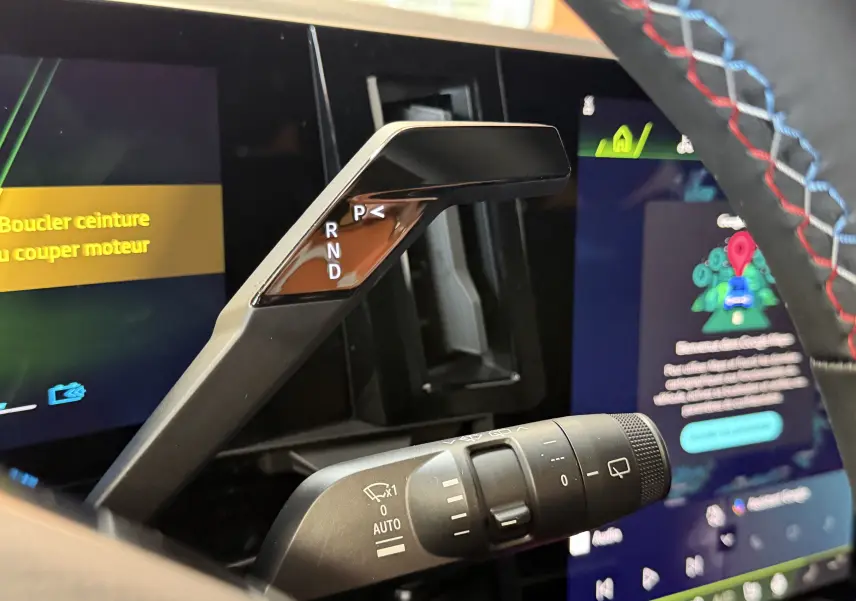 Gros plan sur la commande de boîte auto et le volant avec surpiqûres tricolores du Renault Austral E-Tech 200 Esprit Alpine.