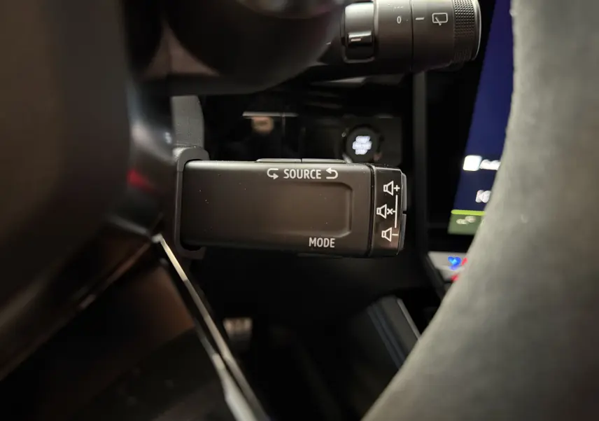 Gros plan sur la commande multimédia au volant du Renault Austral E-Tech 200 Esprit Alpine, intérieur noir avec surpiqûres bleues.