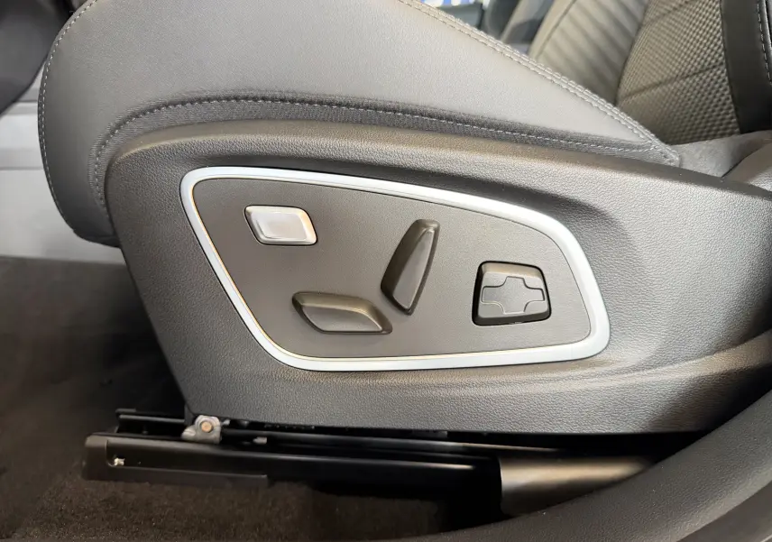 Gros plan sur les commandes électriques du siège avant en sellerie mixte noire du Renault Austral E-Tech 200 Esprit Alpine.