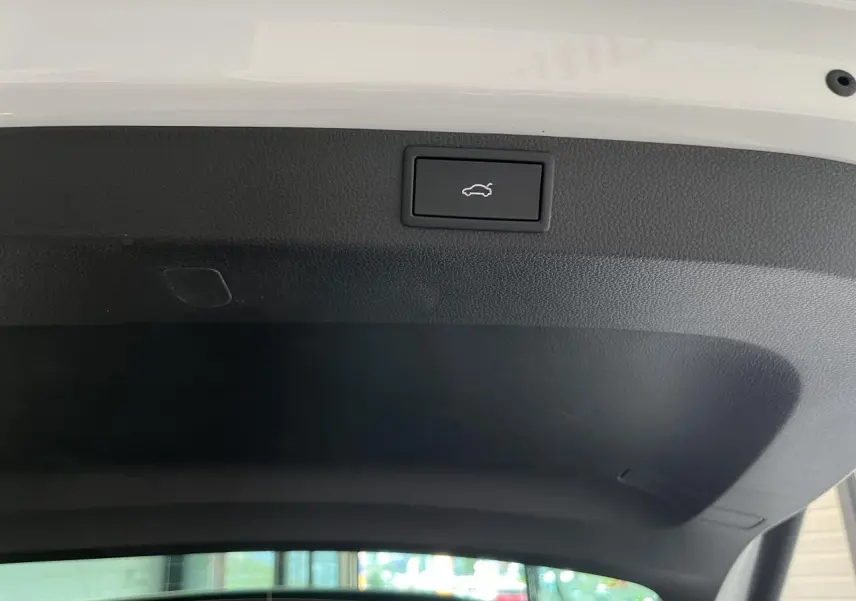 Bouton d'ouverture électrique du hayon sur l'intérieur du coffre noir d'un Skoda Karoq blanc 2025 Sportline