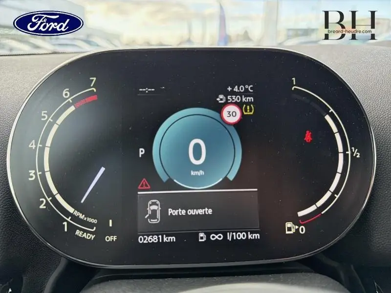 Tableau de bord numérique d'une MINI COUNTRYMAN 2023 avec affichage vitesse, compte-tours et alertes au centre.