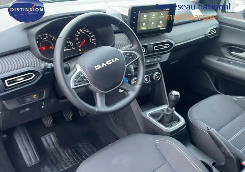 Vue intérieure côté conducteur du Dacia Jogger 2025, tableau de bord noir avec écran tactile et boîte manuelle.