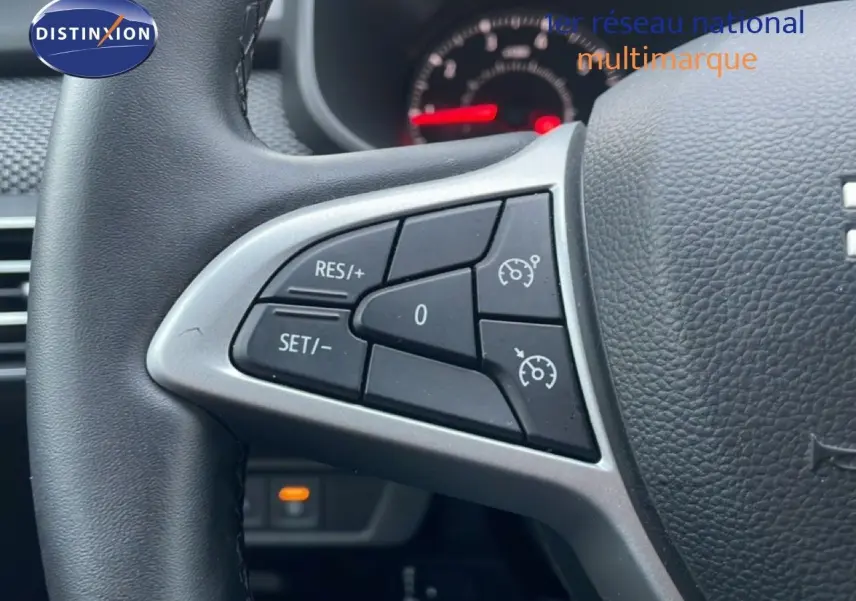 Gros plan sur les commandes au volant à gauche du Dacia Jogger 2025, cuir noir et boutons de régulateur de vitesse.