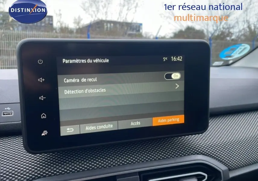 Écran tactile central du tableau de bord du Dacia Jogger affichant les paramètres de caméra de recul et détection d'obstacles.