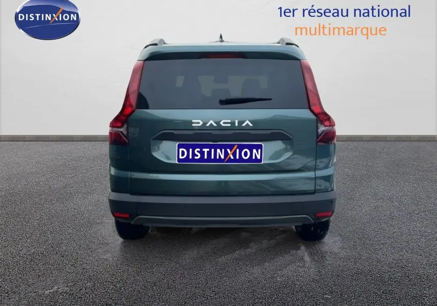 Vue arrière d'un Dacia Jogger 2025 vert cèdre métal avec feux arrière verticaux et logo DACIA bien visible.