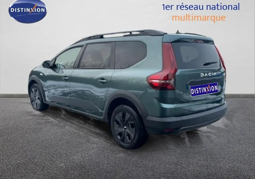 Vue 3/4 arrière droite d'un Dacia Jogger vert cèdre métal avec vitres teintées et jantes noires.