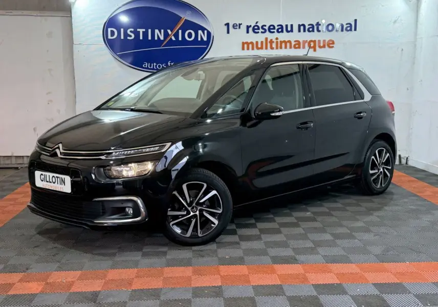 Citroën C4 Spacetourer noir vue 3/4 avant droit en intérieur avec jantes alliage et phares allumés.