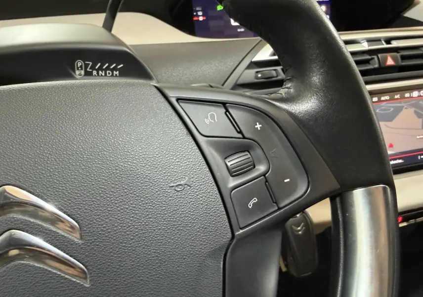 Gros plan sur le volant cuir et alu du Citroën C4 Spacetourer 2020, avec commandes vocales et multimédia visibles.