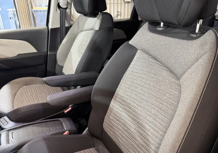 Gros plan sur les sièges avant bi-ton gris et noir du Citroën C4 Spacetourer 2020, avec accoudoirs et ceintures visibles.