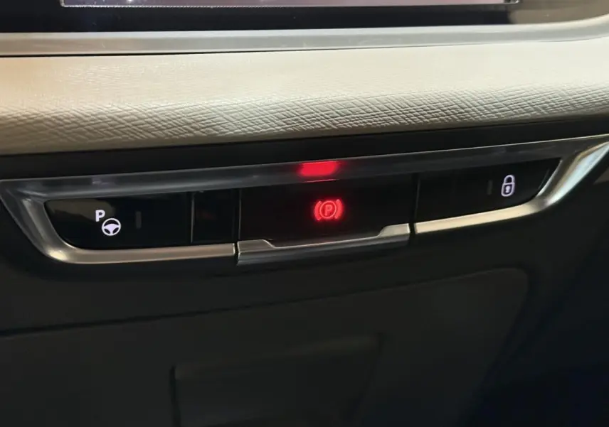 Gros plan sur les commandes de frein à main électrique et verrouillage central du tableau de bord du Citroën C4 Spacetourer noir.