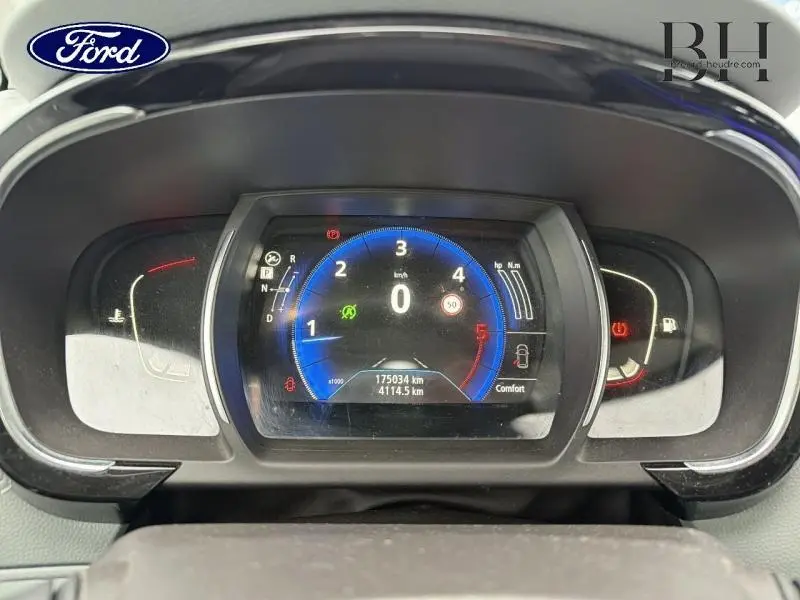 Vue rapprochée du tableau de bord numérique d'un Renault Espace blanc, affichant le compteur et les indicateurs.