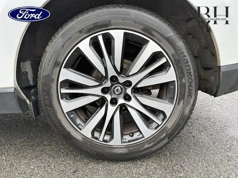 Gros plan sur la jante alu bicolore avec logo Renault, montée sur un pneu Hankook, partie arrière blanche visible.