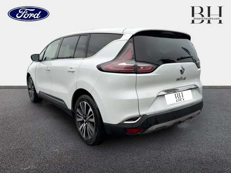 Vue 3/4 arrière droite d'un Renault Espace blanc Glacier avec vitres surteintées et jantes alu distinctives.