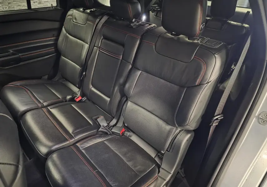 Vue intérieure côté droit sur la banquette arrière en cuir noir avec surpiqûres rouges du Ford Explorer gris 2020.
