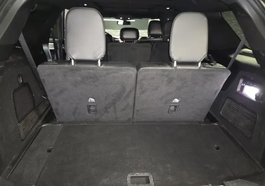 Vue arrière du coffre spacieux du Ford Explorer gris avec banquette arrière relevée et éclairage intérieur actif.