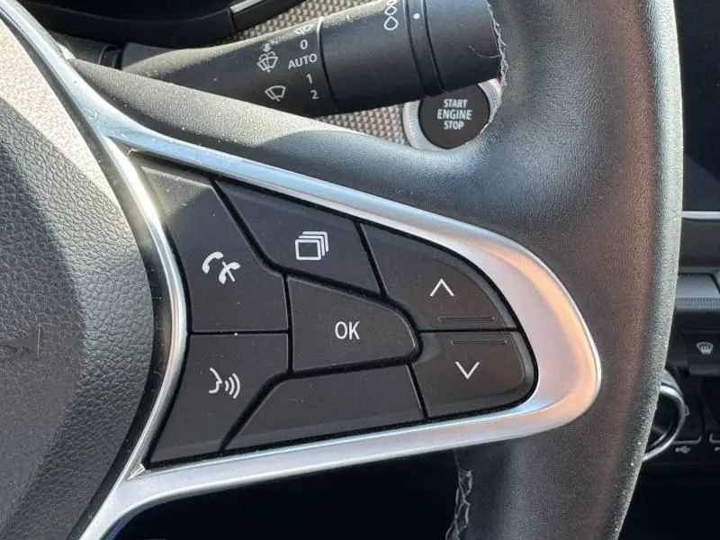Gros plan sur les commandes multifonctions du volant côté droit du Renault Arkana noir métal 2023, avec bouton Start Engine Stop visible.