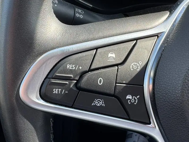 Gros plan sur les commandes de régulateur et d'aide à la conduite au volant côté gauche d'un Renault Arkana noir métal 2023.