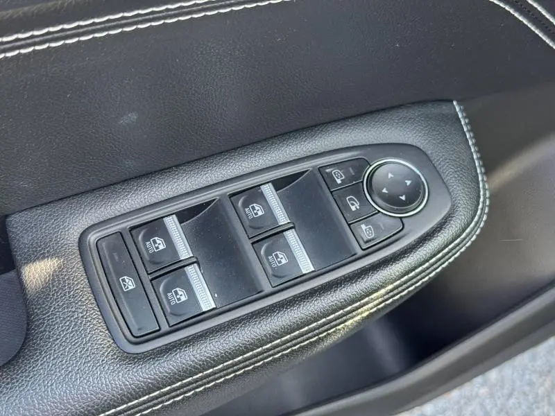 Gros plan sur les commandes de lève-vitres et rétroviseurs sur la porte côté conducteur du Renault Arkana noir métal 2023.