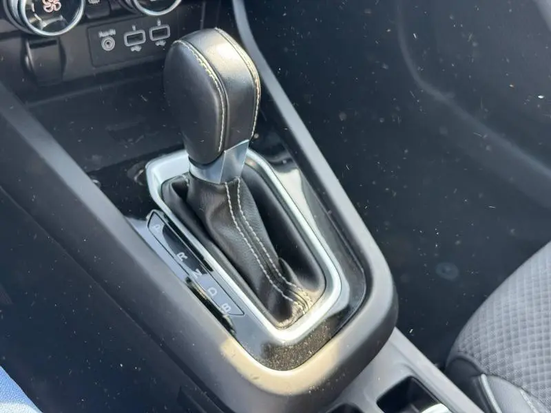 Gros plan sur la commande de boîte automatique noire avec surpiqûres blanches dans le Renault Arkana 2023.